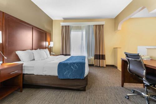 a hotel room with a bed and a desk at Comfort Suites in Findlay