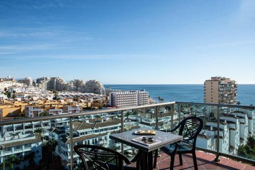 a table and chairs on a balcony with the ocean at Pierre & Vacances Benalmádena Príncipe in Benalmádena