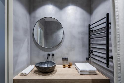 a bathroom with a bowl sink and a mirror at Laisves ave. Apartments Mini in Kaunas