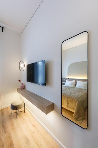 a mirror in a bedroom with a bed and a chair at Laisves ave. Apartments Mini in Kaunas