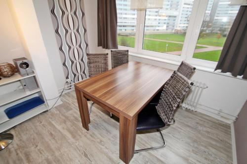 un tavolo in legno e una sedia in una stanza con finestra di Ferienpark N02-009 Ferienpark a Heiligenhafen