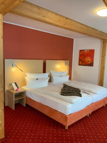 a bedroom with a large bed with white sheets at Altstadthotel Arte in Fulda