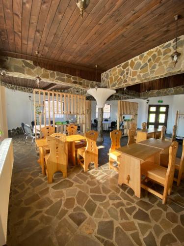 uma sala de jantar com mesas e cadeiras de madeira em Cob Village em Berca