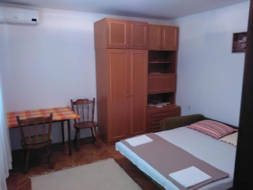 a small room with a bed and a table with chairs at Apartments Špadina in Tisno