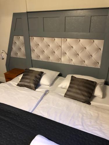 a large bed with two pillows on top of it at Avila Park & SPA in Dziwnówek
