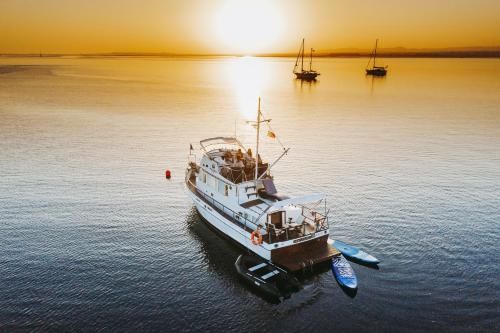 a boat sitting in the water at sunset at Mulubinba SeaHouse in Olhão