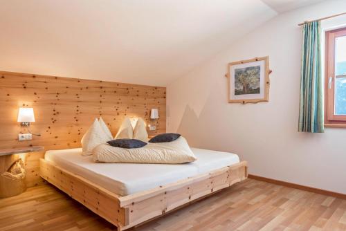 a bedroom with a bed with a wooden headboard at Wasserfall Moarlhof Kastelruth in Castelrotto