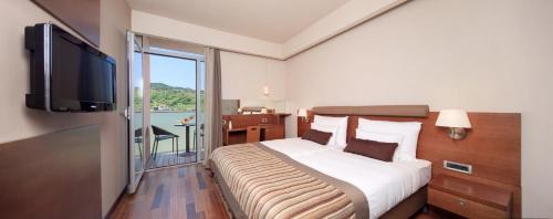 a hotel room with a bed and a flat screen tv at Hotel Kaj in Marija Bistrica
