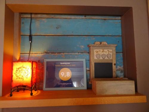 a shelf with a light and a clock and a lamp at L'Eaubergerine in Herbeumont
