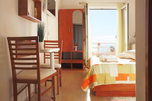 a bedroom with a bed and a table and chairs at Apartments Antonio in Baška Voda
