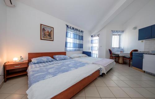 a bedroom with a large bed and a table at Apartments Jelena in Barbat na Rabu