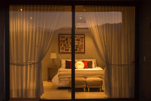 a bedroom with a bed and a window with curtains at Casa de Huéspedes La Azul in Los Árboles