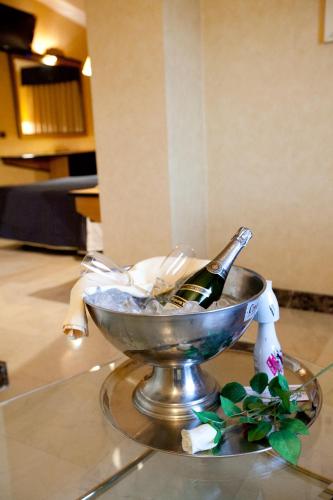 a bottle of champagne in a bowl on a table at Hotel Ciudad de Navalcarnero in Navalcarnero