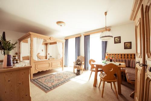 1 dormitorio con mesa de comedor y 1 cama en Frühstückspension Windlegern, en Neukirchen