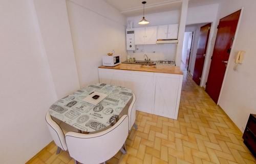 eine kleine Küche mit einem Tisch und einem Waschbecken in der Unterkunft Departamento Parque España in Rosario