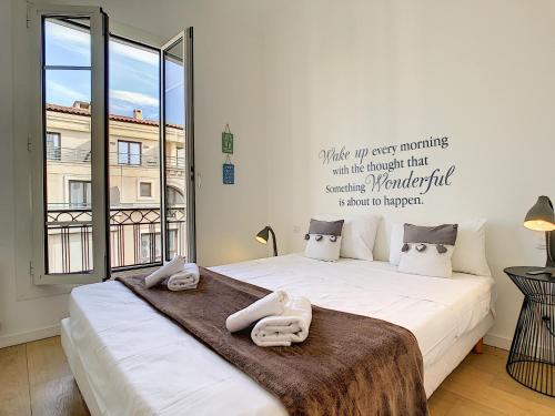 une chambre avec un grand lit avec des serviettes dessus dans l'établissement Nestor&Jeeves - SWEETHEART - Hyper center - Close sea and Old Town, à Nice
