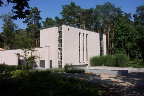 a white building with trees in the background at Nooz - Something Different? in Grobbendonk