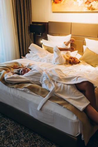 a woman laying on a bed with two babies at Hotel Zeta in Budva