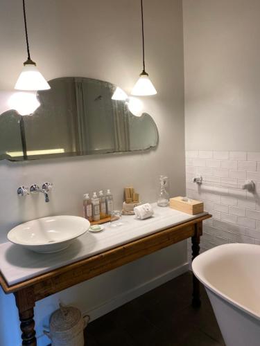 a bathroom with a sink and a tub and a mirror at Mas Generós - Adults-Only Eco Hotel in Fonteta