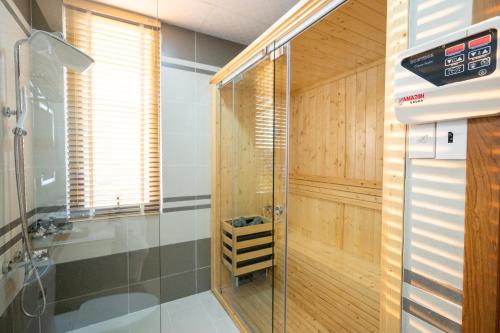 W łazience znajduje się prysznic ze szklanymi drzwiami. w obiekcie La Fleur Premium Central Apartment Hotel w mieście Da Lat