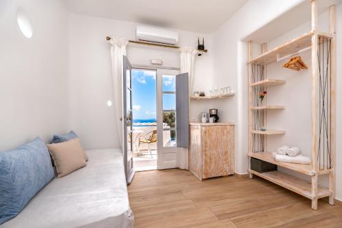 a bedroom with a bed and a view of the ocean at Hotel Thira in Fira