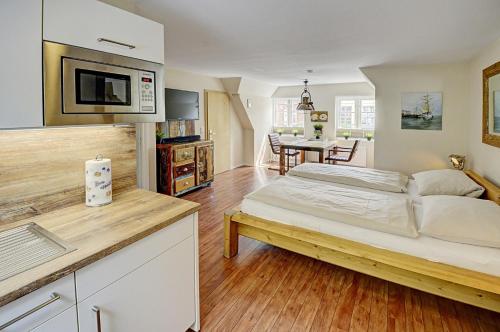 ein großes Schlafzimmer mit einem Bett und einer Küche in der Unterkunft fewo1846 - Kajuete am Nordermarkt - maritim eingerichtetes Studio-Apartment im Stadtzentrum in Flensburg