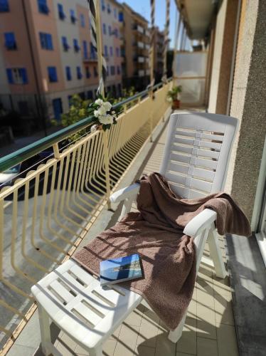 uma cadeira branca sentada numa varanda com um cobertor em Girasole76 em Sestri Levante