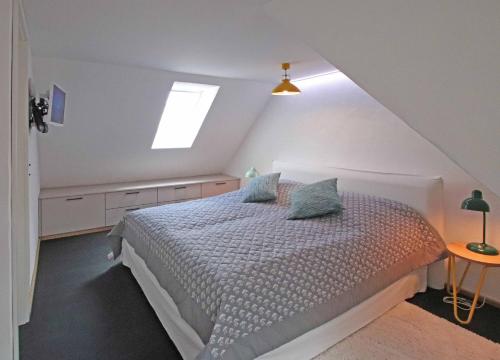 1 dormitorio con 1 cama blanca y ventana en fewo1846 - Lille hus - reizvolles Kapitänshäuschen am Hafen über 3 Ebenen, en Flensburg
