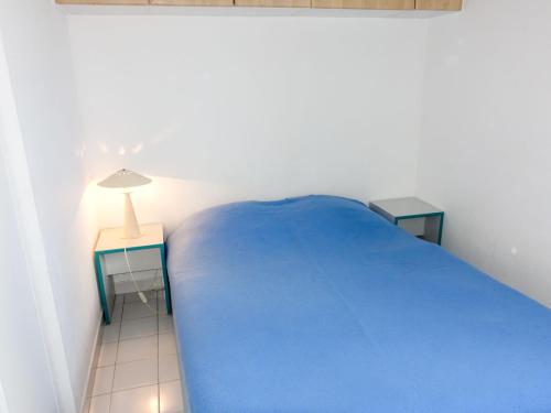 a bedroom with a blue bed and two tables at Apartment Savanna Beach I-2 by Interhome in Cap d'Agde