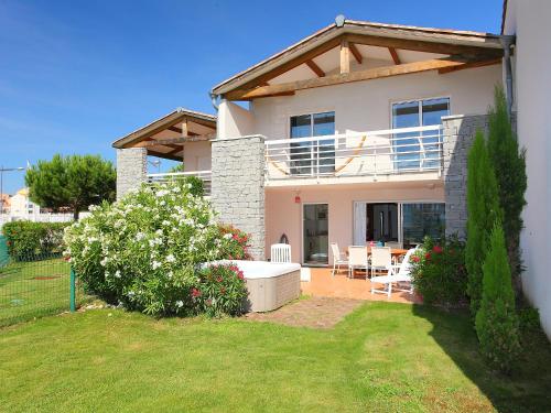 a white house with a table and chairs in a yard at Holiday Home Île St Martin by Interhome in Cap d'Agde