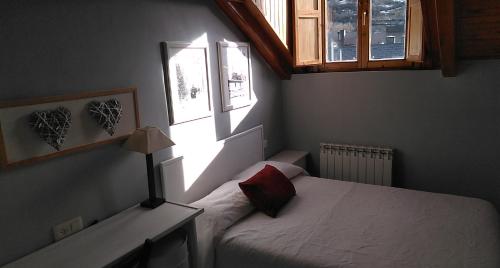 a small bedroom with a bed and a window at EDIFICIO ARDILLAS in Benasque