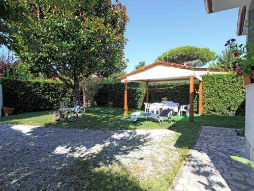 a garden with a table and chairs under a canopy at Villa Sandra by Interhome in Forte dei Marmi