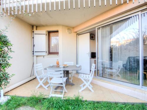 een patio met een tafel en stoelen erop bij Apartment Résidence Capao-1 by Interhome in Cap d'Agde