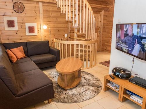a living room with a couch and a tv at Holiday Home Vuosselin trio a by Interhome in Ruka