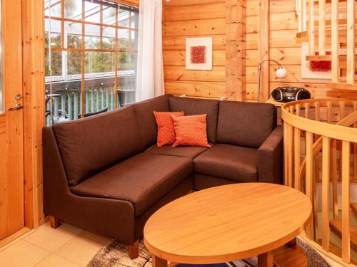 een woonkamer met een bank en een tafel bij Holiday Home Vuosselin trio c by Interhome in Ruka