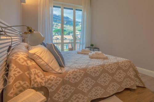 sypialnia z łóżkiem, lampą i oknem w obiekcie Olivia by PortofinoHomes w mieście Santa Margherita Ligure