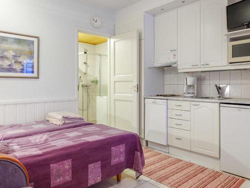 a kitchen with white cabinets and a purple bed in it at Holiday Home Moonlight 111 by Interhome in Levi