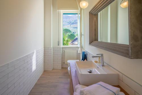 łazienka z umywalką i oknem w obiekcie Olivia by PortofinoHomes w mieście Santa Margherita Ligure