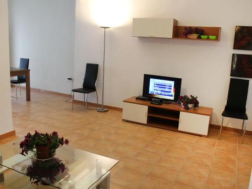 a living room with a tv and a table and chairs at Apartment Albir by Interhome in Altea
