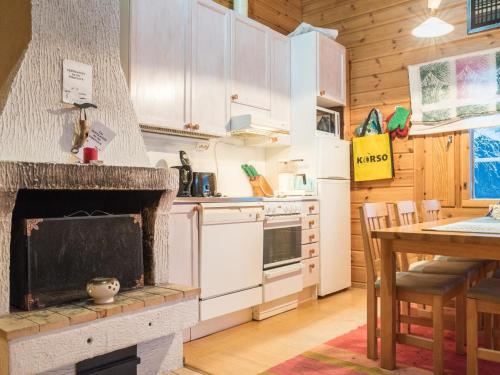 a kitchen with a fireplace and a table with chairs at Holiday Home Lomaylläs h109 -pistopolku 1 a by Interhome in Ylläsjärvi