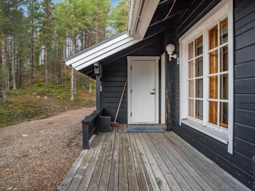 eine Veranda eines schwarzen Hauses mit einer weißen Tür in der Unterkunft Holiday Home Lomaylläs h113-pistopolku 5a by Interhome in Ylläsjärvi