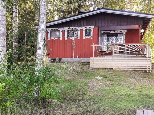Juhanala的住宿－Holiday Home Lepikko by Interhome，红色小屋,在树林里设有门廊