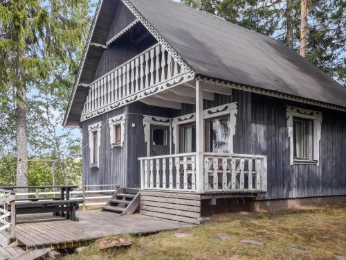 ein schwarzes Haus mit einer Veranda und einer Holzterrasse in der Unterkunft Holiday Home Piilopirtti by Interhome in Juhanala