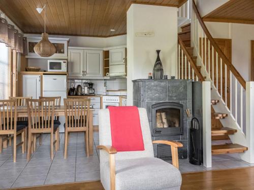 eine Küche und ein Esszimmer mit einem Kamin und einem Tisch in der Unterkunft Holiday Home Alppinuppu by Interhome in Tahkovuori
