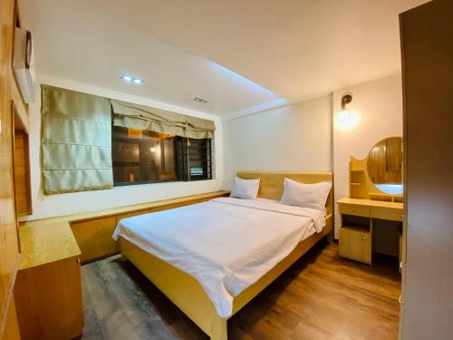 una piccola camera con letto e finestra di Haiphong Backpacker Hostel a Hai Phong