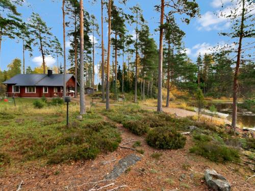 una cabaña en el bosque con un camino delante en Holiday Home Kuusikumpu by Interhome, en Petäjävesi