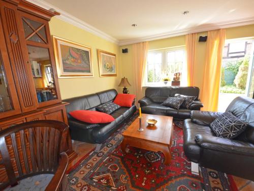 a living room with a black leather couch and red pillows at Holiday Home Fischerhaus by Interhome in Groß Zicker
