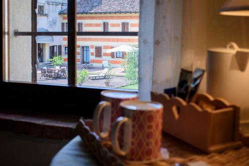 a table with a view of a building from a window at Musella Winery & Relais in San Martino Buon Albergo