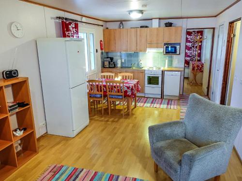 a kitchen and dining room with a table and a refrigerator at Holiday Home Mellaniemi by Interhome in Hietajoensuu