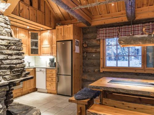 a kitchen with a refrigerator and a table in a cabin at Holiday Home Operonmukka a 8 by Interhome in Levi